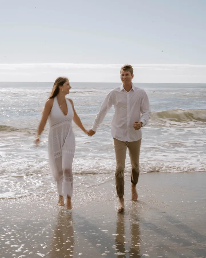 Royce Clemens and his wife walking hand in hand on the beach